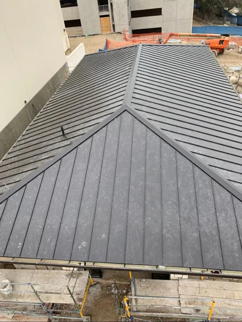 Commercial metal roof construction with crane equipment in Coral Springs